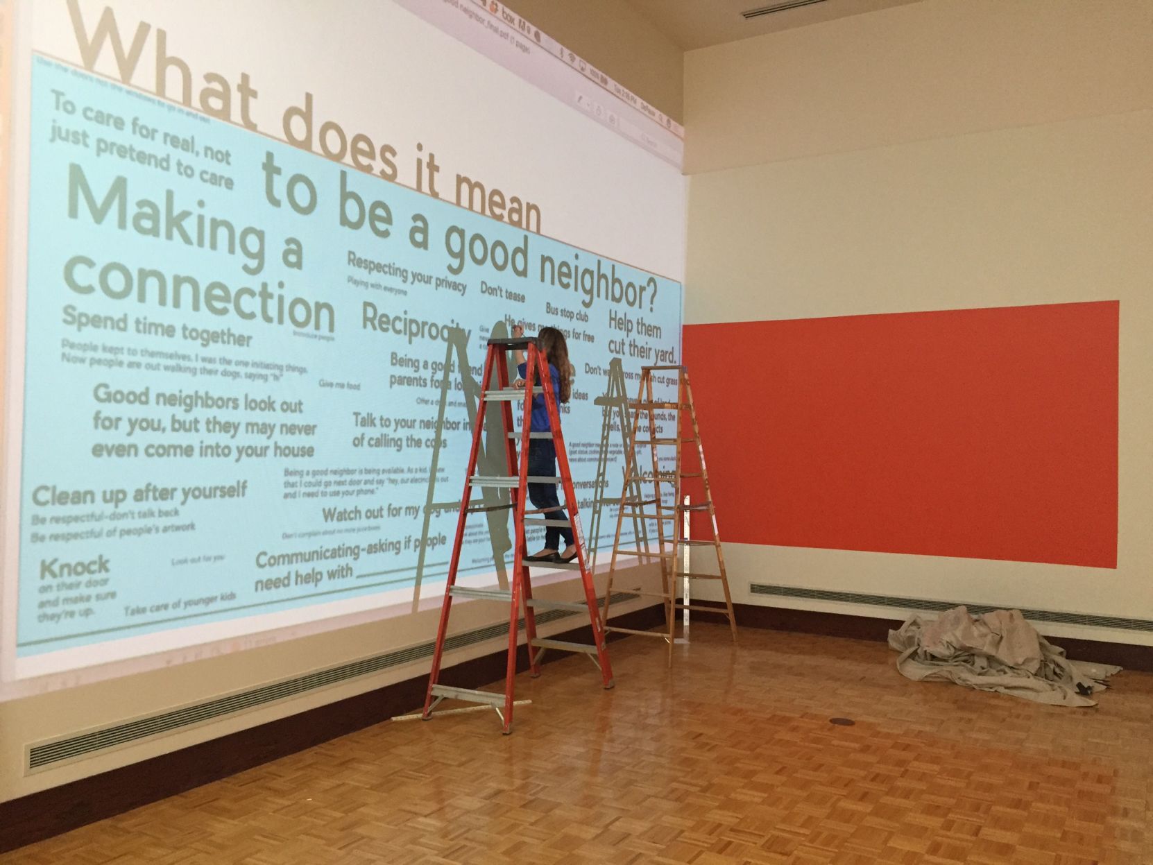 Laura Holzman installing What Does It Mean To Be A Good Neighbor, the House Life Project's contribution to an exhibition on social practice art at UIndy, October 2017. Photo courtesy of Laura Holzman.